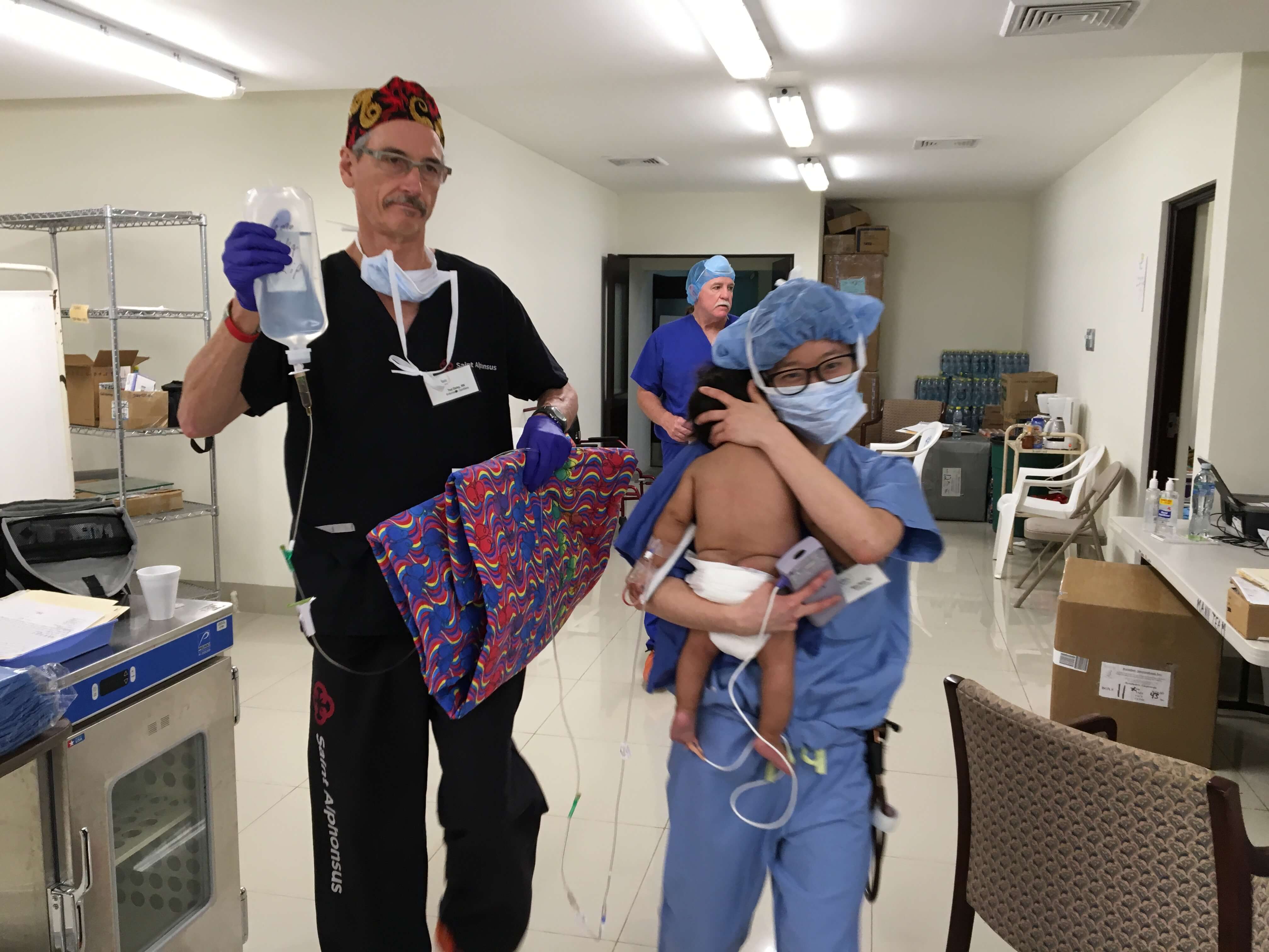 Nurse Ted Daley and anesthesiologist Mary Rhee bring a young patient from the OR to the recovery room.