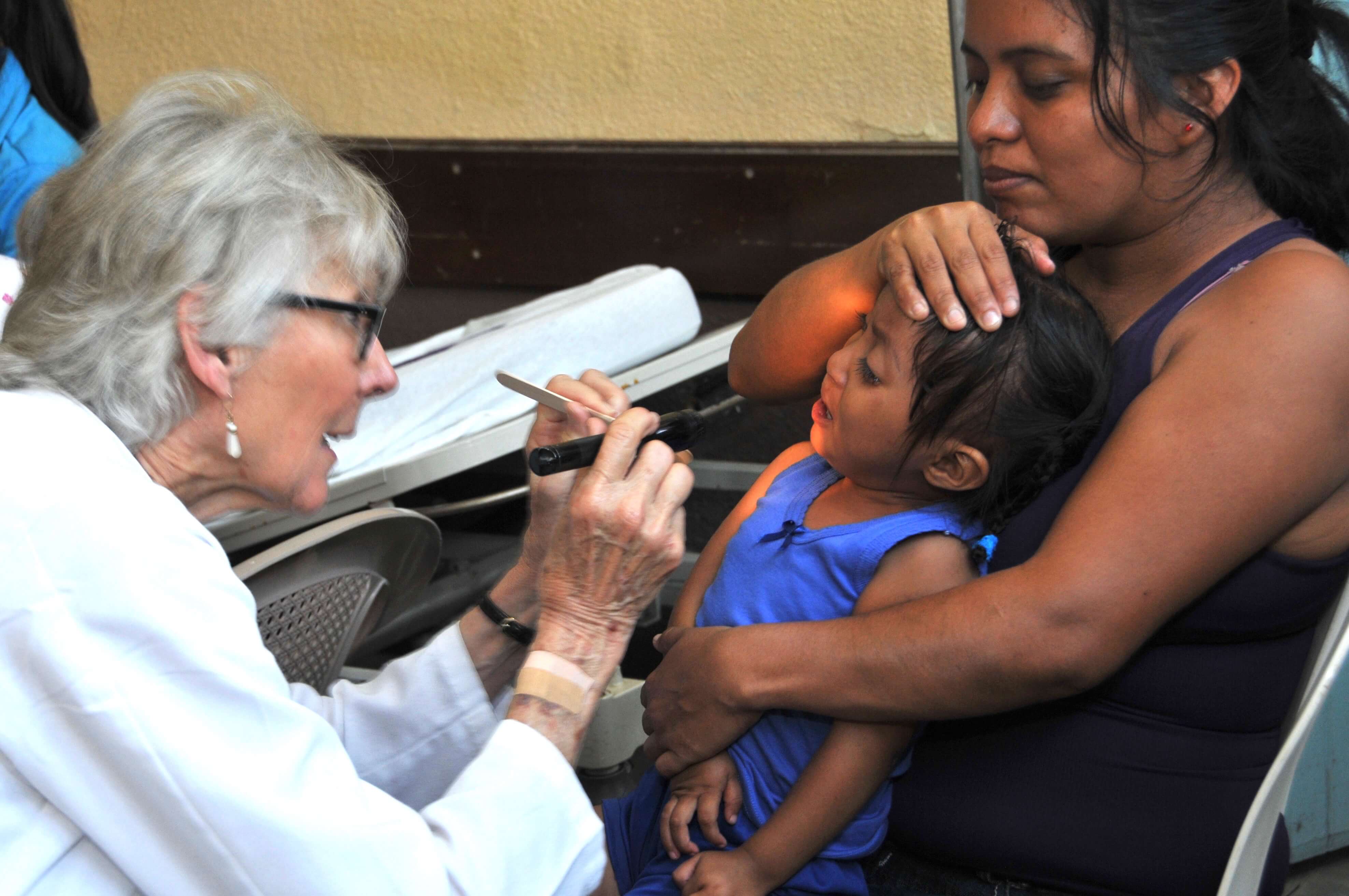 Physician's Assistant Nan Madden examines a child before surgery.